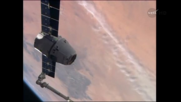 SpaceX Dragon resupply spacecraft grappled by Canada robotic arm for berthing at the International Space Station on Easter Sunday morning April 20, 2014. Backdrop of Erath look like dried out river channel on Mars! Credit: NASA TV