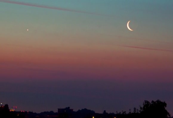 Moon and Venus Conjunction approximately 1 hour before sunrise on 24th June 2014. Looking east over central London with Canary Wharf on the horizon. Credit and copyright: Roger Hutchinson. 