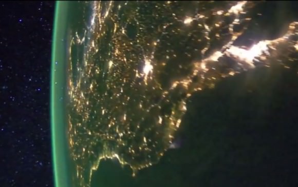 Photo taken of Earth at night from the International Space Station showing bright splashes of city lights and the airglow layer off in the distance rimming the Earth's circumference. Credit: NASA