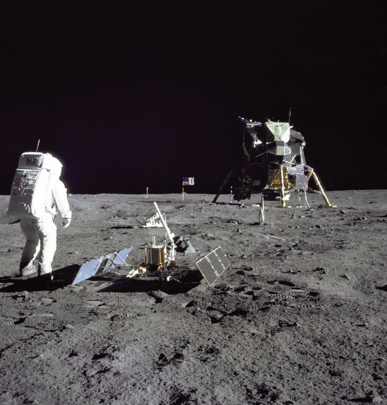 Aldrin Gazes at Tranquility Base. Astronaut and Lunar Module pilot Buzz Aldrin is pictured during the Apollo 11 extravehicular activity on the moon. He had just deployed the Early Apollo Scientific Experiments Package. In the foreground is the Passive Seismic Experiment Package; beyond it is the Laser Ranging Retro-Reflector (LR-3). In the left background is the black and white lunar surface television camera and in the far right background is the Lunar Module "Eagle." Mission commander Neil Armstrong took this photograph with the 70mm lunar surface camera.   Image credit: NASA