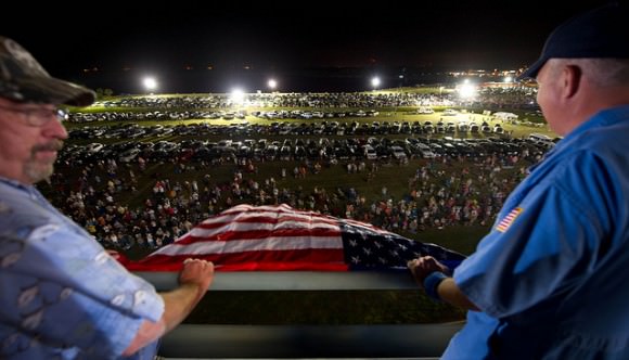 Randy Meyers (left) and Mitchell Bromwell of United Space Alliance, the primary industry partner for space shuttle operations, show off an American flag to crowds of people gathered for the rollout of STS-135 Atlantis on May 31, 2011. Credit: NASA/Bill Ingalls