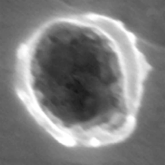 An electron scanning microscope image of an interstellar dust impact on the Stardust spacecraft. The crater is 280 nanometers across. Residue from the dust particle is barely visible in the center. Credit: Rhonda Stroud, Naval Research Laboratory