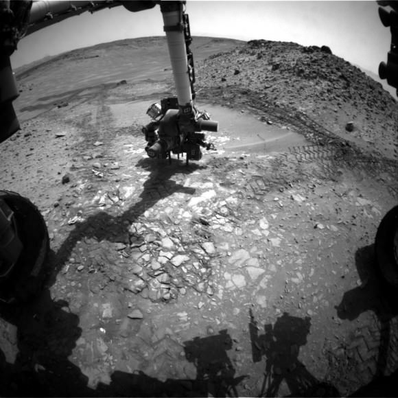 This image from the front Hazcam on NASA's Curiosity Mars rover shows the rover's drill in place during a test of whether the rock beneath it, "Bonanza King," would be an acceptable target for drilling to collect a sample. Subsequent analysis showed the rock budged during the Aug. 19, 2014, test. Credit: NASA/JPL-Caltech