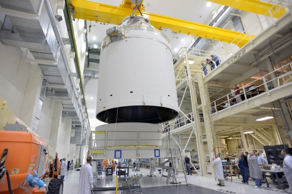Lifting and stacking NASA’s first completed Orion crew and service modules at the Neil Armstrong Operations and Checkout Facility at Kennedy Space Center in Florida in early September 2014.   Credit: NASA/Rad Sinyak