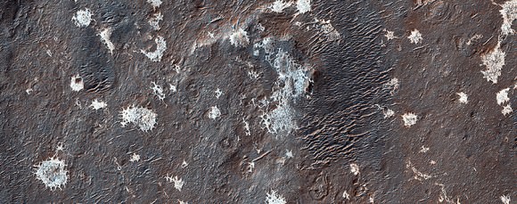 Scientists are still puzzling out the nature and formation of these light-toned deposits in the old Vinogradov Crater on Mars. Picture taken by the High Resolution Imaging Science Experiment (HiRISE) on the Mars Reconnaissance Orbiter. Credit: NASA/JPL/University of Arizona 