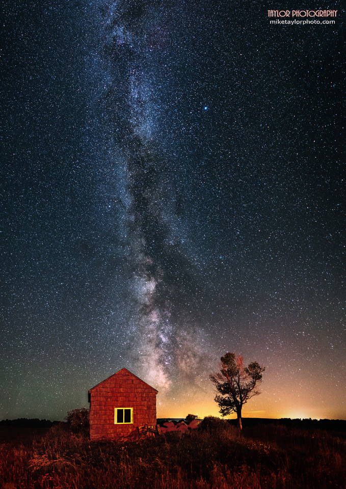 This is a 7 image vertical panorama of the night sky in Maine where the late Summer Milky Way makes a dramatic background for a small shack and tree.  Credit and copyright: Mike Taylor/Mike Taylor Photography. 