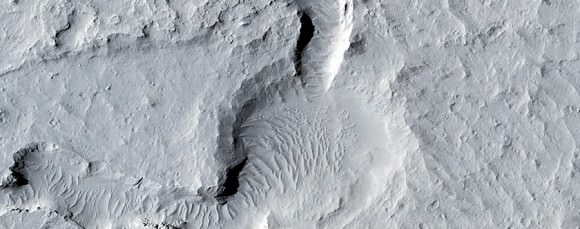 A section of Eastern Elysium Planitia imaged by the Mars Reconnaissance Orbiter's HiRISE camera showing a possible old lava field near dust avalanches stirred up more recently. Credit: NASA/JPL/University of Arizona