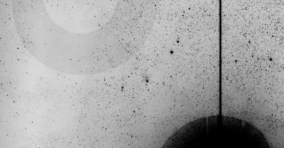 Negative image showing Comet Siding Spring closely approaching Mars today. Credit: Peter Lake