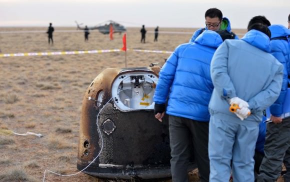 Researchers retrieve the return capsule of China's unmanned lunar orbiter in the central region of north China's Inner Mongolia Autonomous Region, Nov. 1, 2014. Return capsule of China's test lunar orbiter landed successfully early Saturday morning in north China's Inner Mongolia Autonomous Region, according to the Beijing Aerospace Control Center. Credit: Xinhua/Ren Junchuan