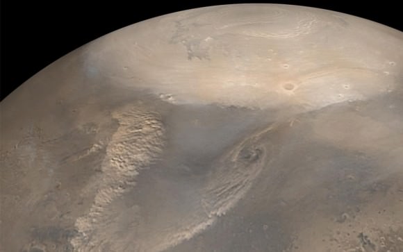 Early Spring Dust Storms at the North Pole of Mars. Early spring typically brings dust storms to northern polar Mars. As the north polar cap begins to thaw, the temperature difference between the cold frost region and recently thawed surface results in swirling winds. The choppy dust clouds of several dust storms are visible in this mosaic of images taken by the Mars Global Surveyor spacecraft in 2002. The white polar cap is frozen carbon dioxide. (NASA/JPL/Malin Space Science Systems)