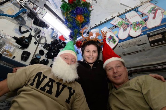 ISS astronauts Barry “Butch” Wilmore, NASA, Samantha Cristoforetti, ESA and Terry Virts, NASA send Christmas 2014 greetings from the space station to the people of Earth.  Credit: NASA/ESA