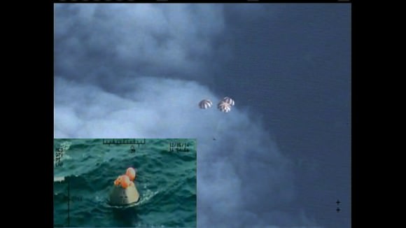 Following a perfect launch on Dec. 5, 2014 and more than four hours in Earth's orbit, NASA's Orion spacecraft is seen from an unpiloted aircraft descending under three massive red and white main parachutes and then shortly after its bullseye splashdown in the Pacific Ocean, 600 miles southwest of San Diego. Credit: NASA 