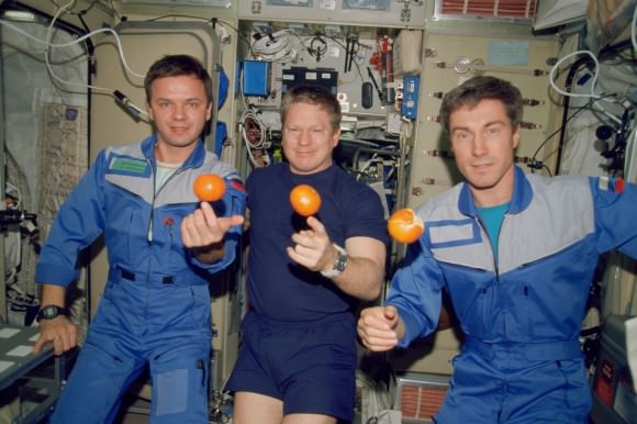 The Expedition 1 crew with fresh oranges on the International Space Station in December 2000. From left, Yuri Gidzenko (Roscosmos), Bill Shepherd (NASA) and Sergei Krikalev (Roscosmos). Credit: NASA