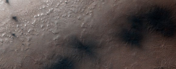 On Aug. 25, 2014, more fans and blotches appear on the Martian landscape around "Inca City", a location in the southern polar region, as the ice bursts in the springtime sun. Image obtained by the Mars Reconnaissance Orbiter's HiRISE camera. Credit: NASA/JPL/University of Arizona