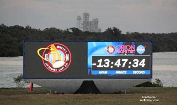A new countdown display has been constructed in the place of the former analog countdown clock at the Press Site at NASA's Kennedy Space Center in Florida for Orion’s first launch. The display is a modern, digital LED display akin to stadium monitors. It allows television images to be shown along with numbers.  Note former shuttle launch pad 39A in the background above clock.   Credit: Ken Kremer – kenkremer.com