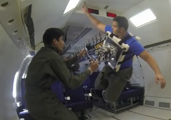 NASA-funded researchers test "gecko grippers" on a simulated-microgravity flight to see how effective they could be for snagging satellites. Here, a researcher has strapped spacecraft-like panels to his body to perform the test. Credit: NASA/YouTube (screenshot)