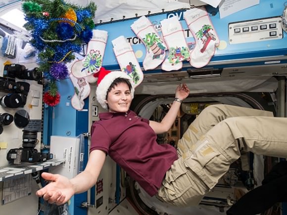 Italian astronaut Samantha Cristoforetti is in the holiday spirit as the station is decorated with stockings for each crew member and a tree.  Credit: NASA/ESA