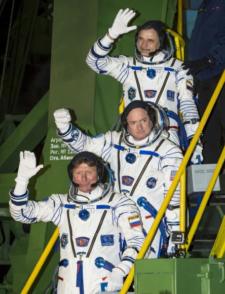 Expedition 43 crew members Mikhail Kornienko of the Russian Federal Space Agency (Roscosmos), top, NASA astronaut Scott Kelly, center, and Gennady Padalka of Roscosmos wave farewell as they board the Soyuz TMA-16M spacecraft ahead of their launch to the International Space Station.  Credit:  NASA/Bill Ingalls