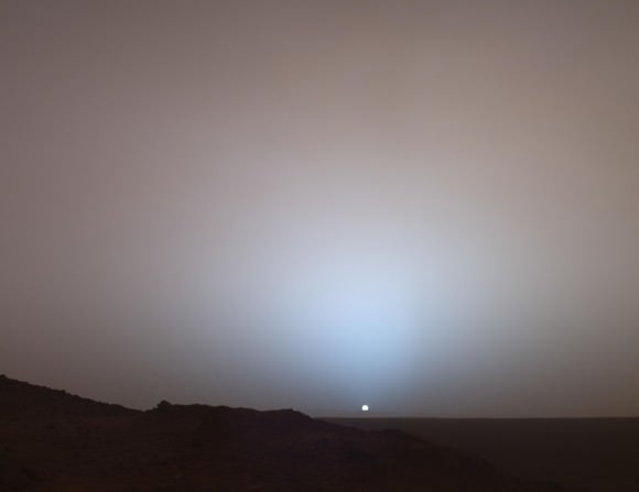 Wide view of sunset over Gusev Crater taken by NASA's Spirit Rover in 2005. Both blue aureole and pink sky are seen. Because of the fine nature of Martian dust, it can scatter blue light coming from the Sun forward towards the observer. Credit: NASA/JPL-Caltech