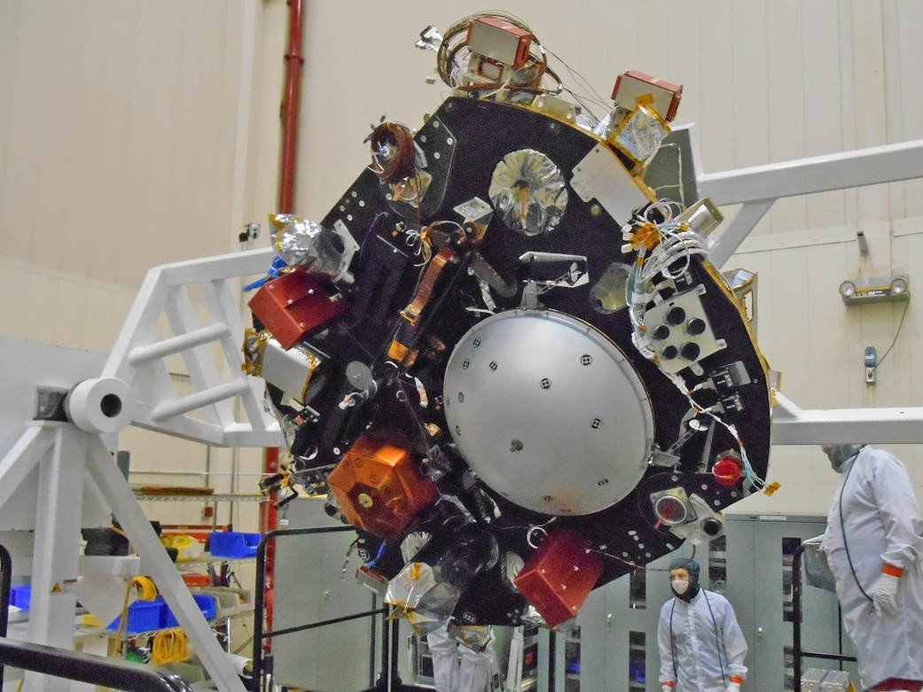 The science deck of NASA's InSight lander is being turned over in this April 29, 2015, photo from InSight assembly and testing operations inside a clean room at Lockheed Martin Space Systems, Denver.  The large circular component on the deck is the protective covering to be placed over InSight's seismometer after the seismometer is placed directly onto the Martian ground.   Credits: NASA/JPL-Caltech/Lockheed Martin