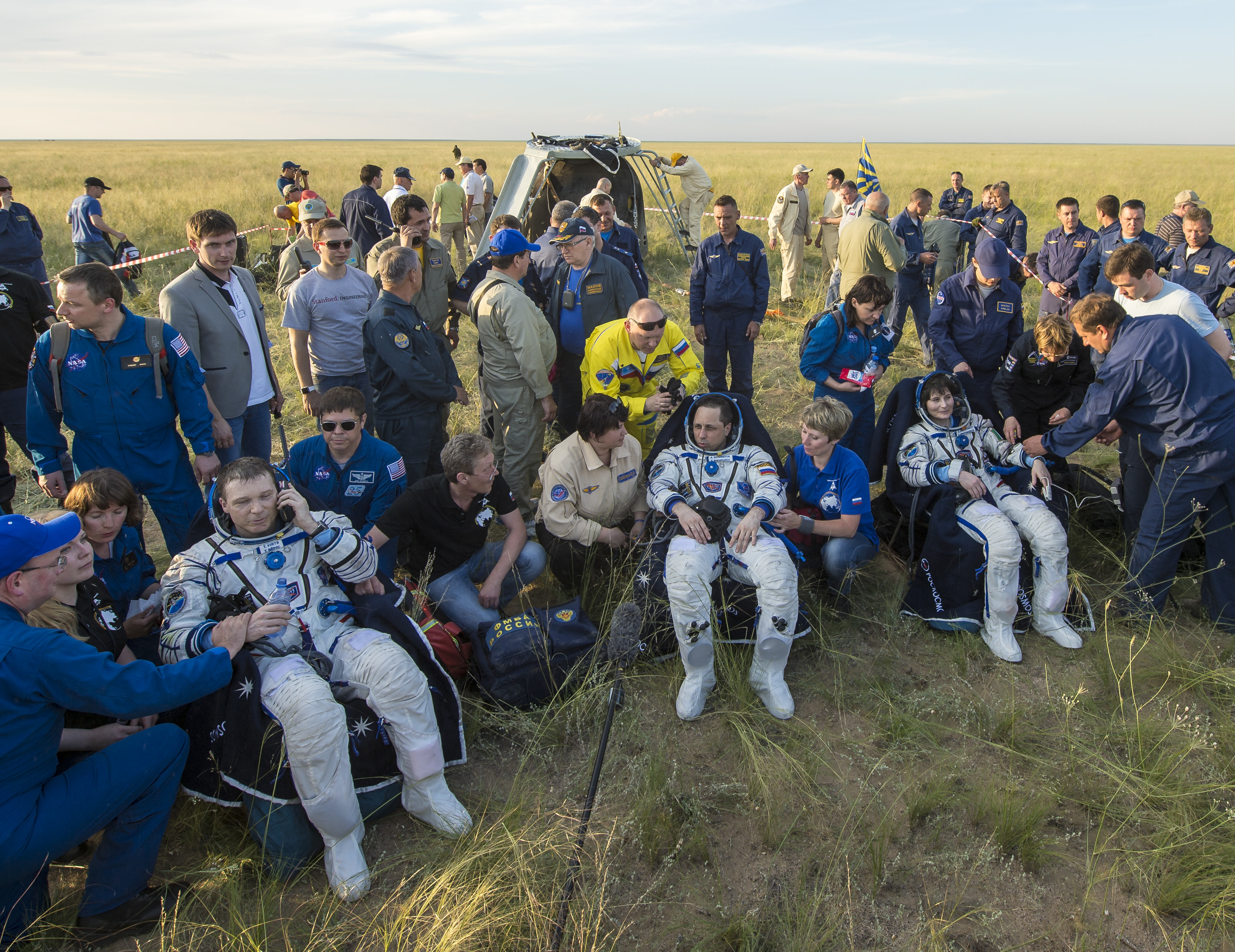 Expedition 43 commander Terry Virts of NASA, left, cosmonaut Anton Shkaplerov of the Russian Federal Space Agency (Roscosmos), center, and Italian astronaut Samantha Cristoforetti from European Space Agency (ESA) sit in chairs outside the Soyuz TMA-15M spacecraft just minutes after they landed in a remote area near the town of Zhezkazgan, Kazakhstan on Thursday, June 11, 2015. Virtz, Shkaplerov, and Cristoforetti are returning after more than six months onboard the International Space Station where they served as members of the Expedition 42 and 43 crews. Photo Credit: (NASA/Bill Ingalls)