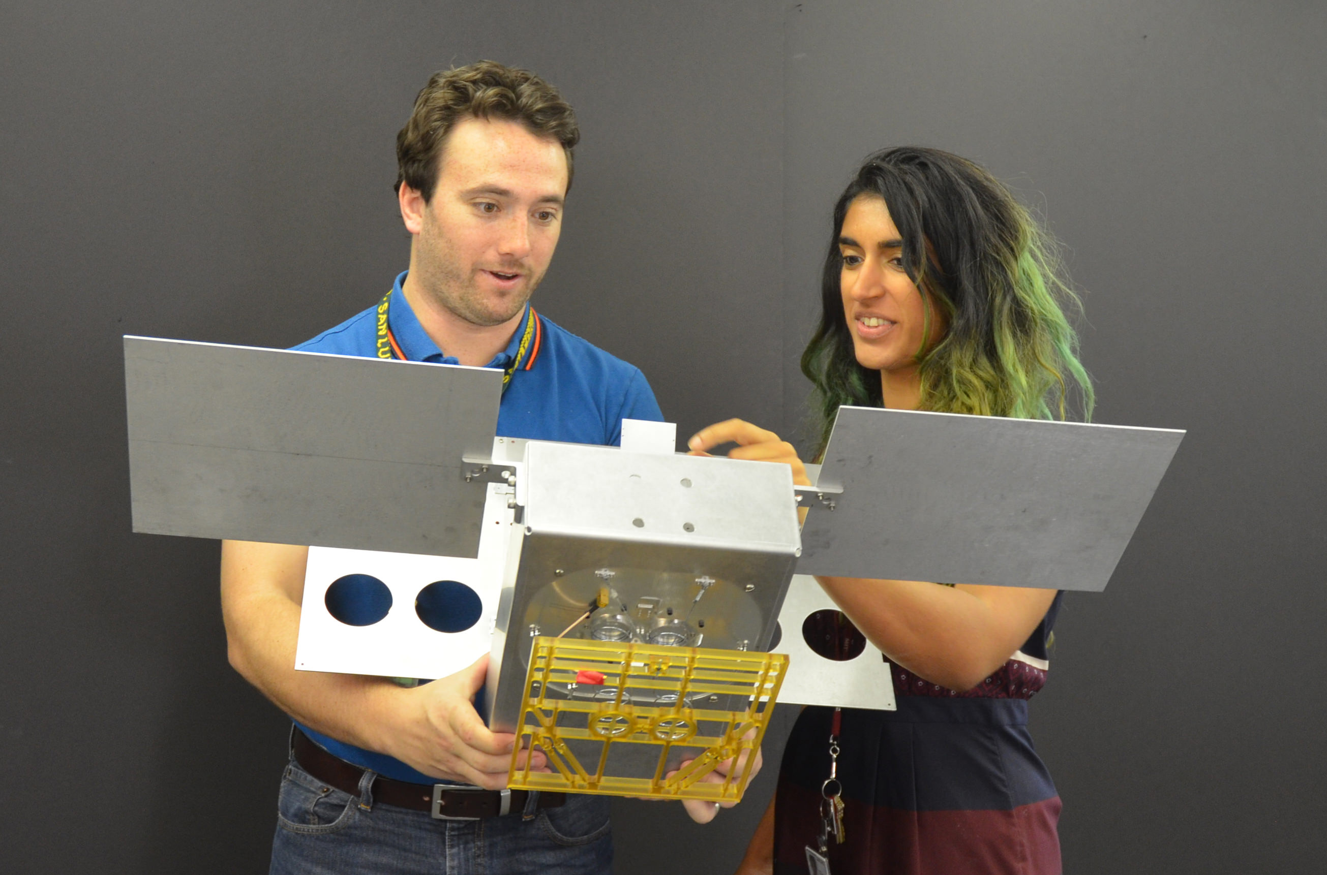 Engineers for NASA's MarCO technology demonstration display a full-scale mechanical mock-up of the small craft in development as part of NASA's next mission to Mars. Mechanical engineer Joel Steinkraus and systems engineer Farah Alibay are on the team at NASA's Jet Propulsion Laboratory, Pasadena, California, preparing twin MarCO (Mars Cube One) CubeSats for a March 2016 launch.  Credit: NASA/JPL-Caltech