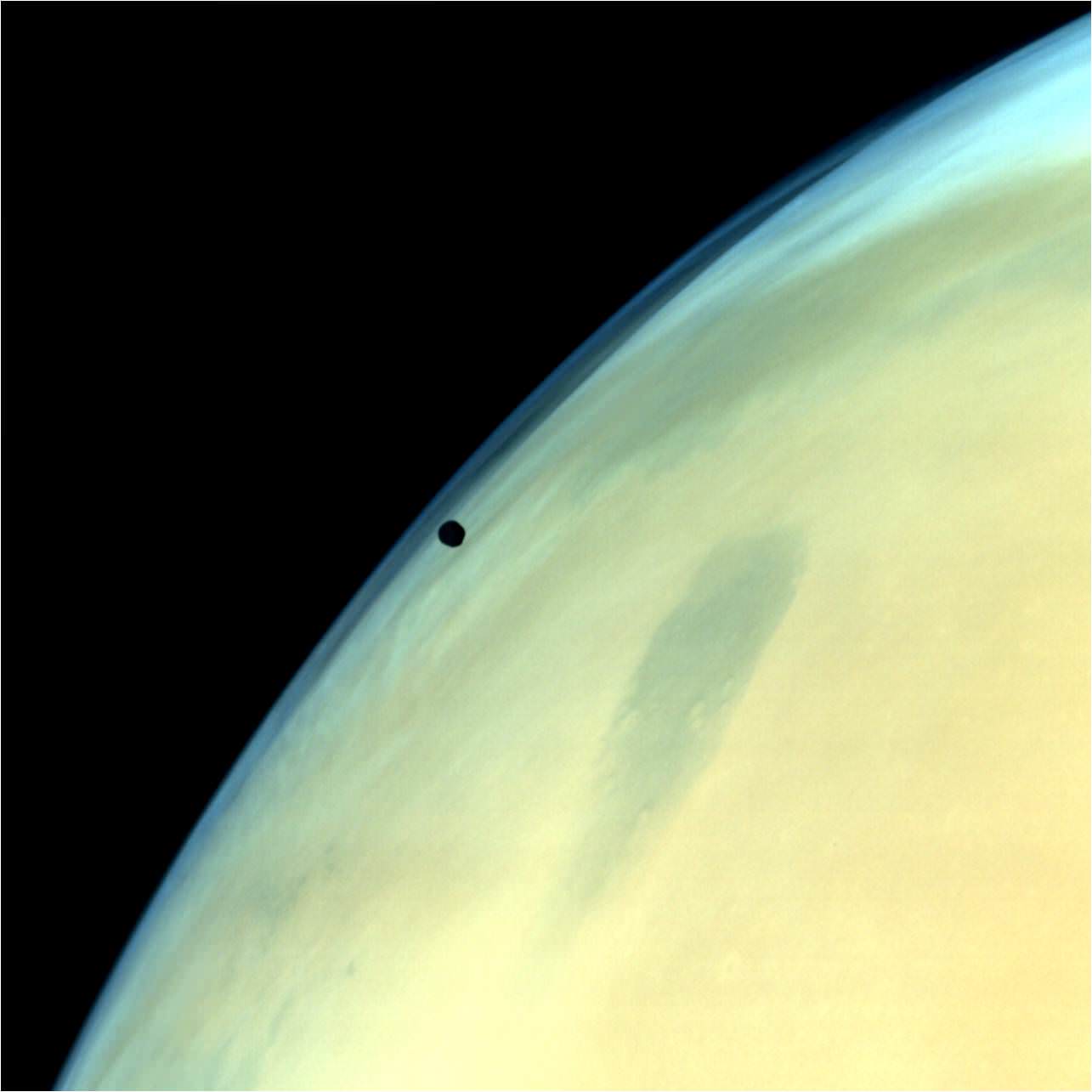 Phobos, one of the two natural satellites of Mars silhouetted against the Martian surface.  Credit: ISRO