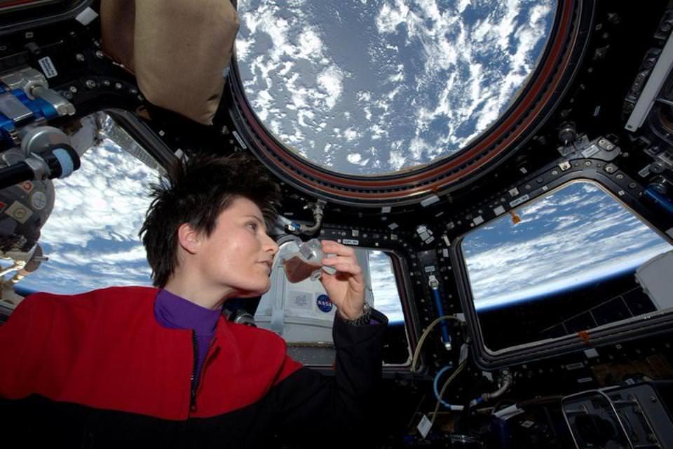 ESA (European Space Agency) astronaut Samantha Cristoforetti enjoys a drink from the new ISSpresso machine. The espresso device allows crews to make tea, coffee, broth, or other hot beverages they might enjoy.  Credit: NASA