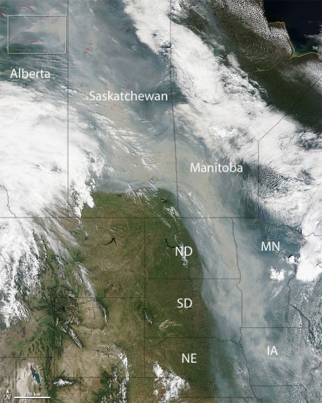 On June 29, 2015 NASA’s Terra satellite captured this image of a river of smoke pouring across the Canadian provinces and central U.S. from hundreds of wildfires (seen at upper left) in western Canada. The difference in color between clouds true clouds and smoke is obvious. Credit: NASA image courtesy Jeff Schmaltz, LANCE/EOSDIS MODIS Rapid Response Team at NASA GSFC