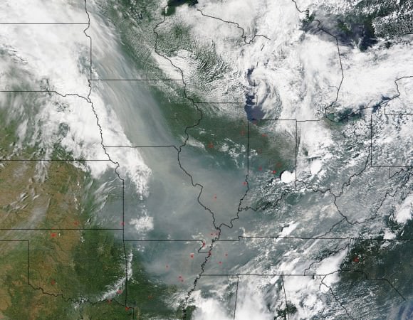 This image taken by the Moderate Resolution Imaging Spectroradiometer (MODIS) instrument aboard the Terra satellite on June 30, 2015.  Residents of the states affected by the smoke will notice much more vivid sunsets during the time the smoke is in the air.  The size of the smoke particles is just right for filtering out other colors meaning that red, pink and orange colors can be seen more vividly in the sky. NASA image courtesy Jeff Schmaltz, MODIS Rapid Response Team. Caption: NASA/Goddard, Lynn Jenner