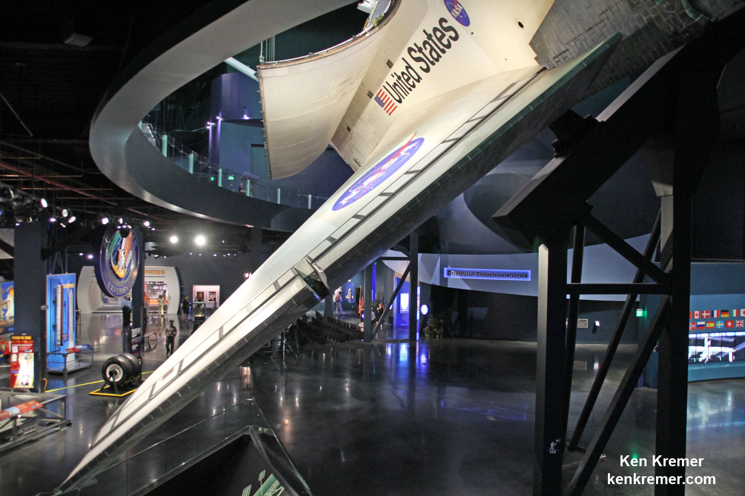 “Forever Remembered” public memorial tribute to the fallen crews of the Columbia and Challenger Space Shuttle orbiters is located on the ground floor of the Space Shuttle Atlantis exhibit at the Kennedy Space Center Visitor Complex in Florida, visible just below the shuttle wing in this photo.  Credit: Ken Kremer/kenkremer.com