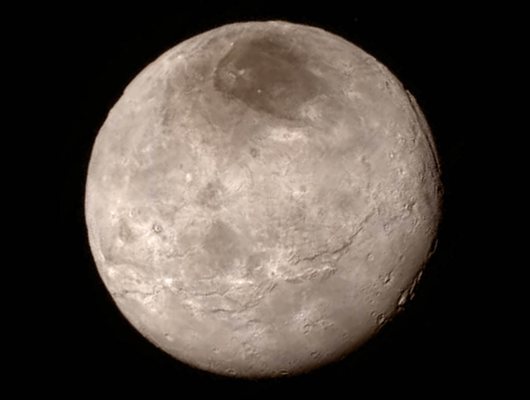 Crisp new view of Pluto’s largest moon, Charon shows a swath of cliffs and troughs stretches about 600 miles (1,000 kilometers) from left to right, suggesting widespread fracturing of Charon’s crust, likely a result of internal processes. At upper right, along the moon’s curving edge, is a canyon estimated to be 4 to 6 miles (7 to 9 kilometers) deep.  Credit: NASA-JHUAPL-SwRI
