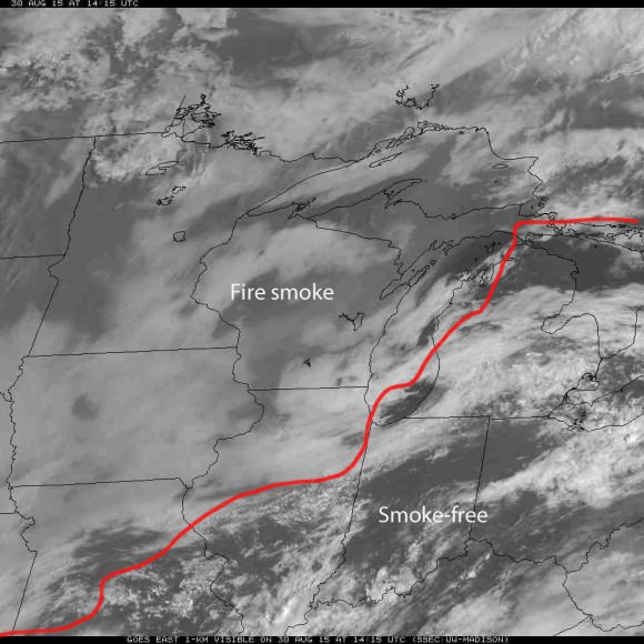 GOES-8 satellite view of the central U.S. taken at 8:15 a.m. CDT August 30, 2015 show a veil of grayish forest fire smoke covering much of the Midwest with clearer conditions to the southeast. The red line is the approximate border between the two. Credit: NOAA