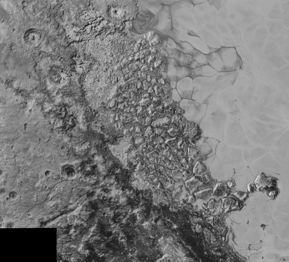 In the center of this 300-mile (470-kilometer) wide image of Pluto from NASA’s New Horizons spacecraft is a large region of jumbled, broken terrain on the northwestern edge of the vast, icy plain informally called Sputnik Planum, to the right. The smallest visible features are 0.5 miles (0.8 kilometers) in size. This image was taken as New Horizons flew past Pluto on July 14, 2015, from a distance of 50,000 miles (80,000 kilometers). Credit: NASA/Johns Hopkins University Applied Physics Laboratory/Southwest Research Institute