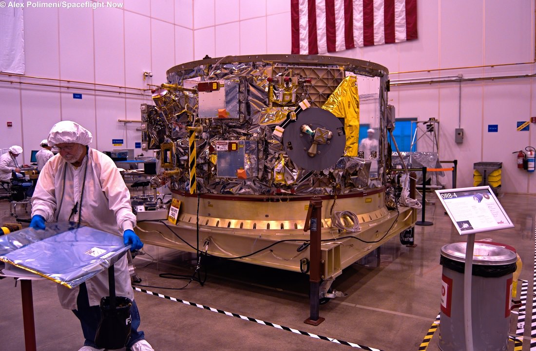 The Orbital Sciences OA-4 service module sits in the cleanroom, with a large portion of the electronics on the vehicle visible in this photograph. The International Space Station grapple hook is visible. Copyright © Alex Polimeni