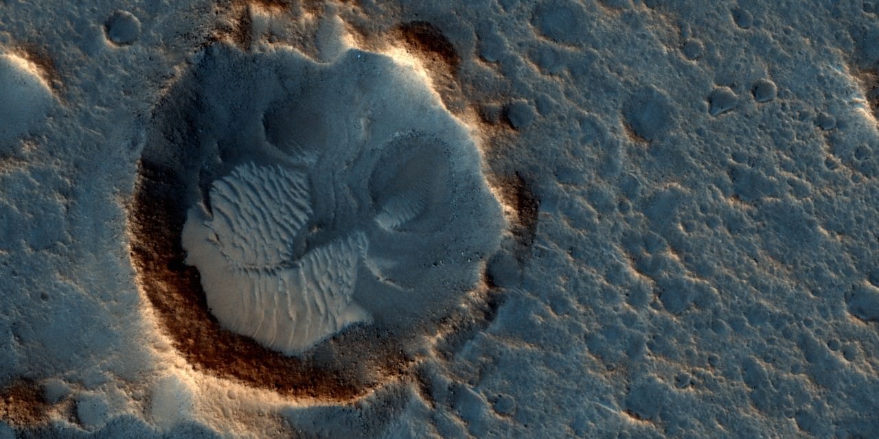 This May 2015 image from the HiRISE camera on NASA's Mars Reconnaissance Orbiter shows a location on Mars associated with the best-selling novel and Hollywood movie, "The Martian." It is in a region called Acidalia Planitia, at the landing site for the science-fiction tale's Ares 3 mission.  For the story's central character, Acidalia Planitia is within driving distance from where NASA's Mars Pathfinder, with its Sojourner rover, landed in 1997. Credits: NASA/JPL-Caltech/Univ. of Arizona