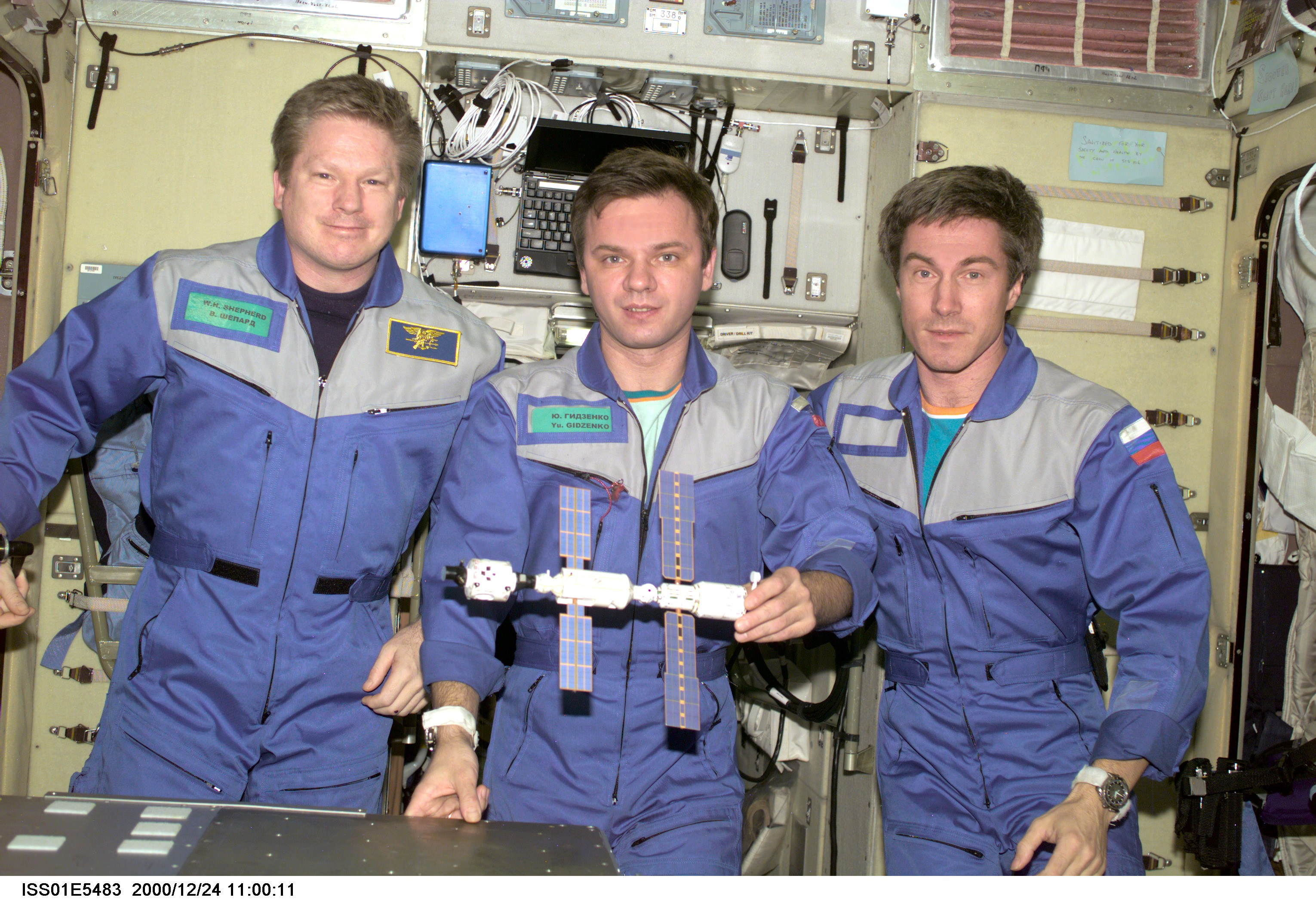 In this photo, Expedition 1 crew members (from left to right) Commander Bill Shepherd, and Flight Engineers Yuri Gidzenko and Sergei Krikalev pose with a model of their home away from home.  Image Credit: NASA