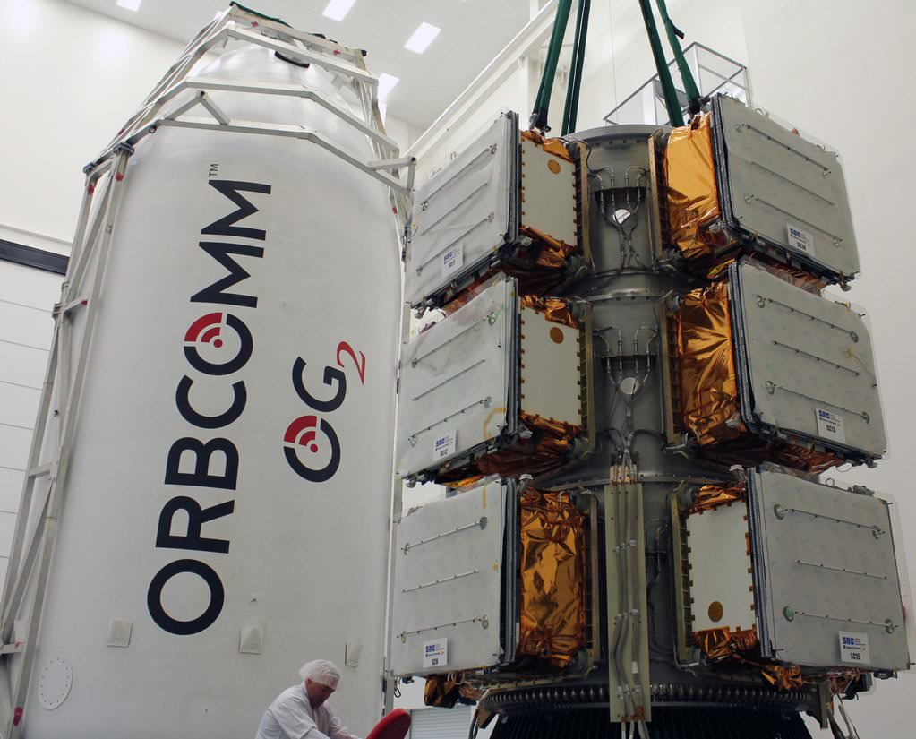 View of the eleven ORBCOMM OG2 satellites beside the payload fairing of the SpaceX Falcon 9 rocket.  Credit: Orbcomm/SpaceX