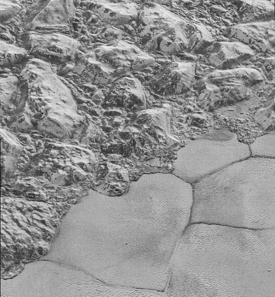 The Mountainous Shoreline of Sputnik Planum on Pluto. Great blocks of Pluto’s water-ice crust appear jammed together in the informally named al-Idrisi mountains. Some mountain sides appear coated in dark material, while other sides are bright. Credit: NASA/Johns Hopkins University Applied Physics Laboratory/Southwest Research Institute.