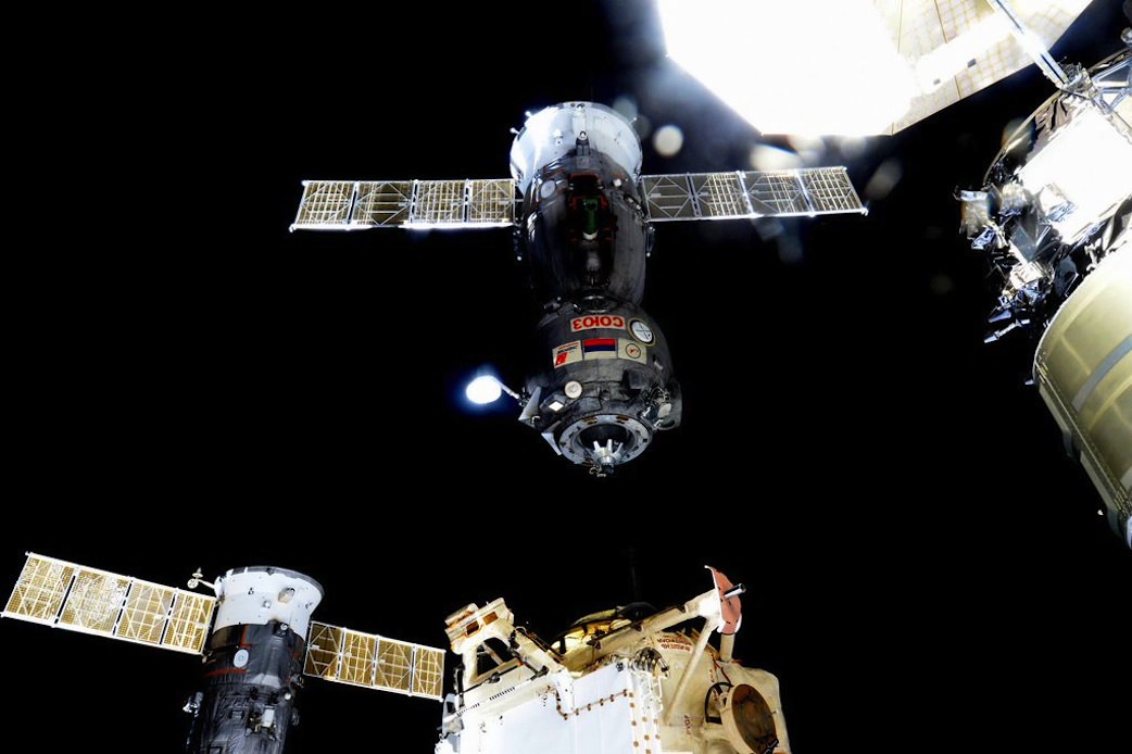 Expedition 46 Commander Scott Kelly of NASA captured this image, from aboard the International Space Station, of the Dec. 11, 2015 undocking and departure of the Soyuz TMA-17M carrying home Expedition 45 crew members Kjell Lindgren of NASA, Oleg Kononenko of the Russian Federal Space Agency and Kimiya Yui of the Japan Aerospace Exploration Agency after their 141-day mission on the orbital laboratory. Newly arrived Cygnus cargo ship and solar panels seen at upper right. Credits: NASA/Scott Kelly