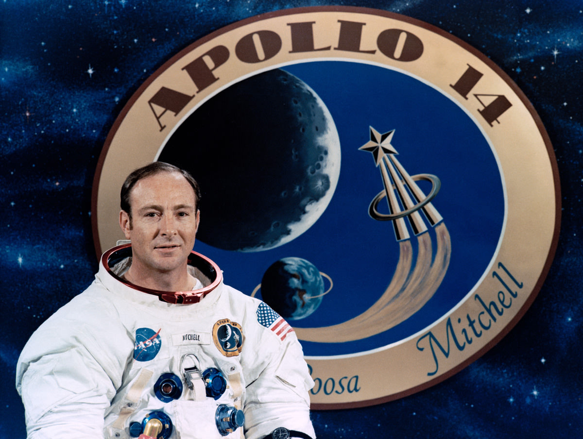 Apollo astronaut Edgar Mitchell in front of a graphic of the mission patch.  Credits: NASA