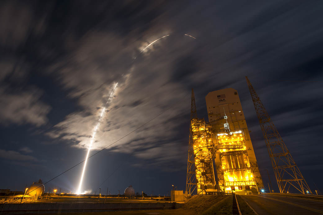Streak shot shows United Launch Alliance Atlas V rocket carrying Orbital ATK's Cygnus spacecraft soaring over Space Launch Complex- 37 housing upcoming Delta IV Heavy rocket after lift off from nearby Space Launch Complex 41 on Cape Canaveral Air Force Station in Florida at 11:05 p.m. EDT on March 22, 2016.  The Cygnus is on a resupply mission to the International Space Station and scheduled to arrive at the orbiting laboratory Saturday, March 26.  Credit: United Launch Alliance/Ben Cooper