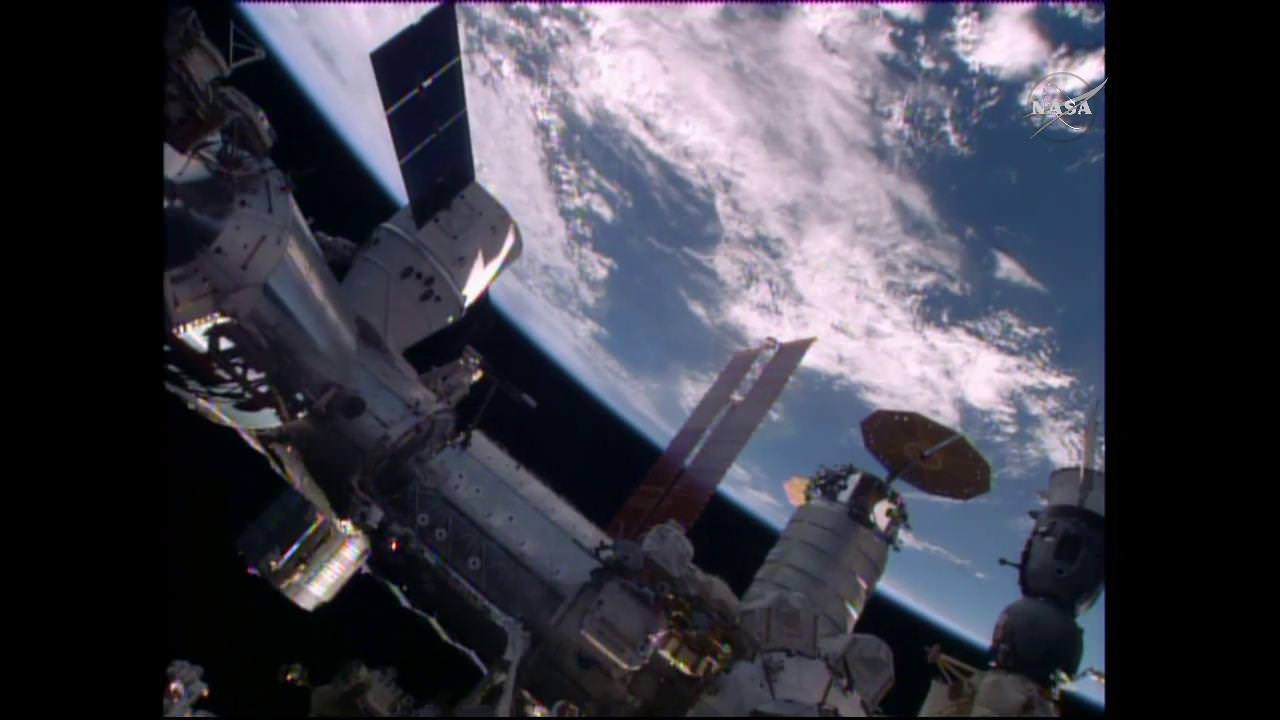 The SpaceX Dragon is seen shortly after it was mated to the Harmony module. The Cygnus cargo craft with its circular solar arrays and the Soyuz TMA-19M spacecraft (bottom right) are also seen in this view. Credit: NASA TV