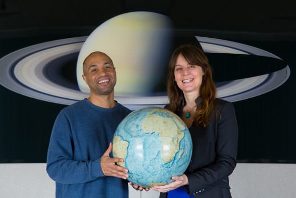 Ramses Ramirez, left, and Lisa Kaltenegger hold a replica of our own habitable world, as they hunt for other places in the universe where life can thrive. Credit: Chris Kitchen/University Photo