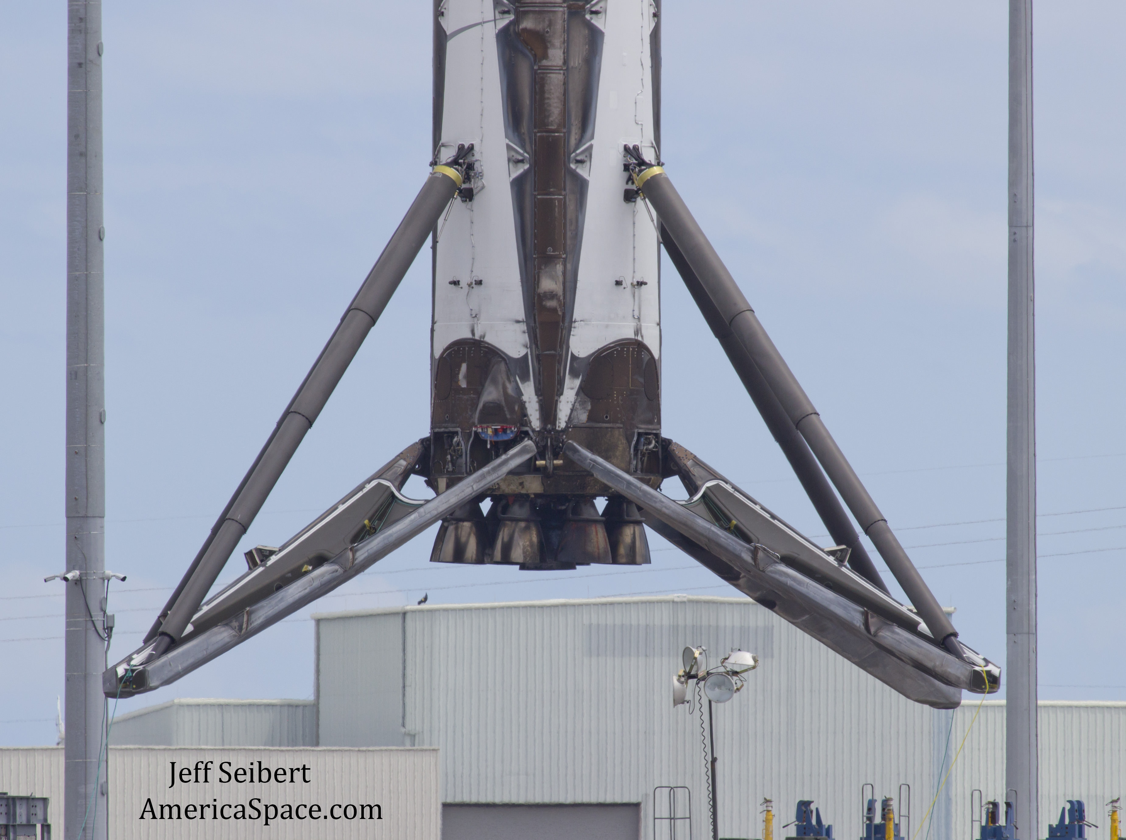 First stage booster from the SpaceX JCSAT-14 launch hoisted by crane on May 10, 2016 from drone ship to work pedestal on land 12 hours after arriving back in Port Canaveral, Florida.  Credit: Jeff Seibert/AmericaSpace 