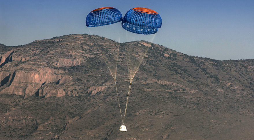New Shepard's crew capsule is seen descending with its parachutes deployed. The capsule's landing is cushioned by firing rockets after the parachutes have done their job. Image: Blue Origin