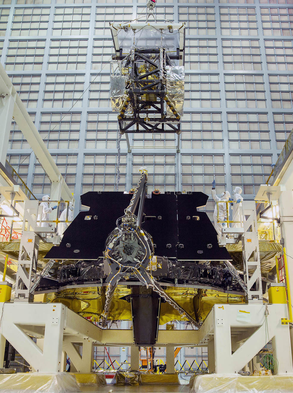 In this rare view, the James Webb Space Telescope team crane lifted the science instrument package for installation into the telescope structure.  Credits: NASA/Chris Gunn