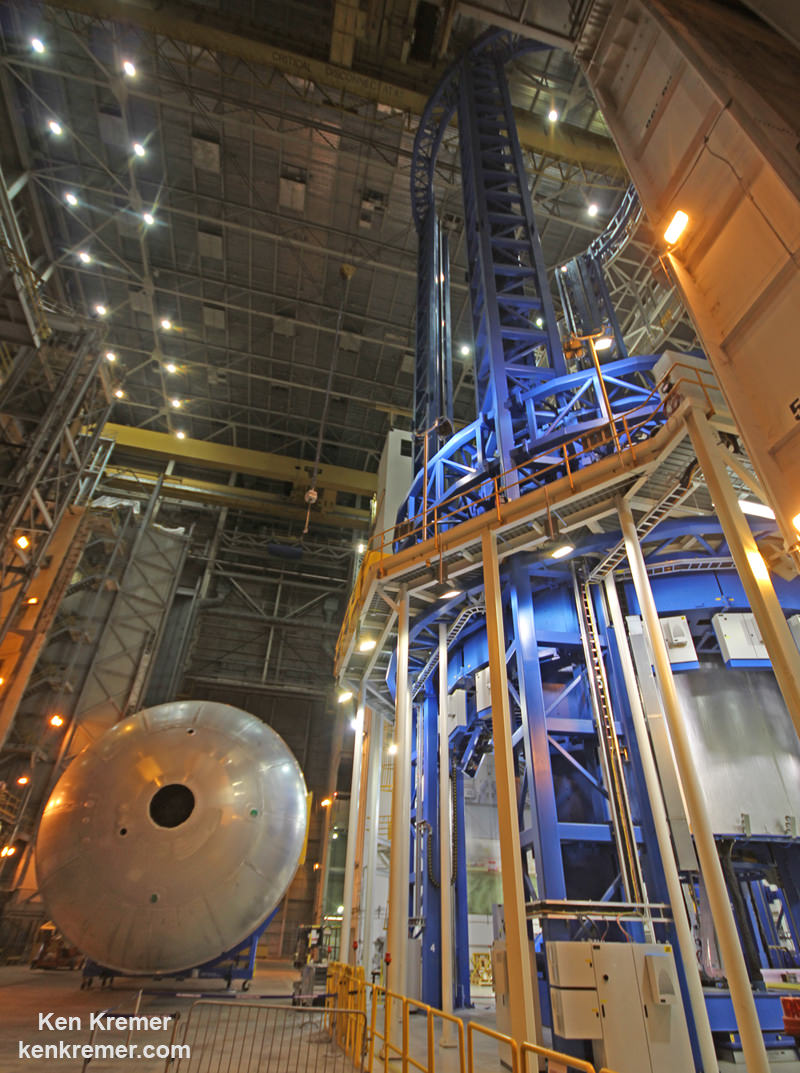 The newly assembled first liquid hydrogen tank, also called the qualification test article, for NASA's new Space Launch System (SLS) heavy lift rocket lies horizontally beside the Vertical Assembly Center robotic weld machine (blue) on July 22, 2016. It was lifted out of the welder (top) after final welding was just completed at NASA’s Michoud Assembly Facility in New Orleans.  Credit: Ken Kremer/kenkremer.com