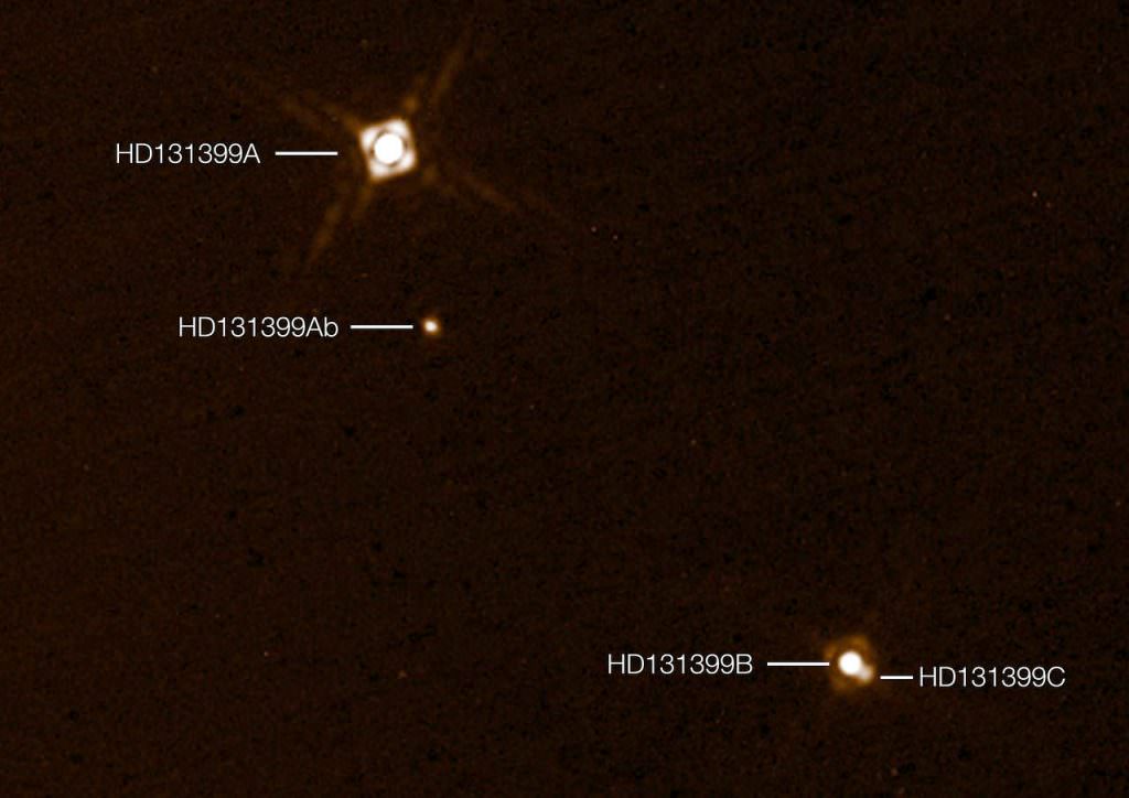 This annotated composite image shows the newly discovered exoplanet HD 131399Ab in the triple-star system HD 131399. The image of the planet was obtained with the SPHERE imager on the ESO Very Large Telescope in Chile. This is the first exoplanet to be discovered by SPHERE and one of very few directly-imaged planets. With a temperature of around 580 degrees Celsius and an estimated mass of four Jupiter masses, it is also one of the coldest and least massive directly-imaged exoplanets. This picture was created from two separate SPHERE observations: one to image the three stars and one to detect the faint planet. The planet appears vastly brighter in this image than in would in reality in comparison to the stars. Credit: ESO/K. Wagner et al.