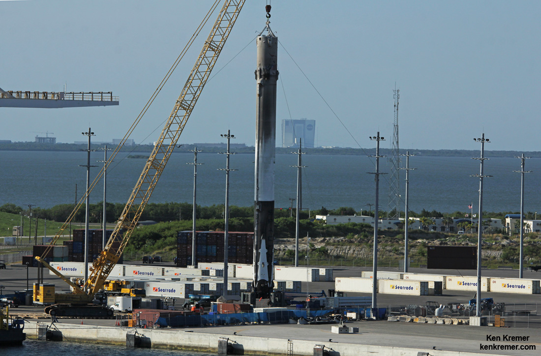 This recovered 156-foot-tall (47-meter) SpaceX Falcon 9 first stage has arrived back into Port Canaveral, FL after successfully launching JCSAT-16 Japanese communications satellite to orbit on Aug. 14, 2016 from Space Launch Complex 40 at Cape Canaveral Air Force Station, Fl. NASA’s VAB in the background.  Credit: Ken Kremer/kenkremer.com